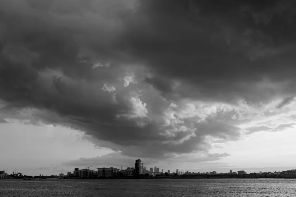 View across the Thames with dark clouds funnelling down towards London City Airport