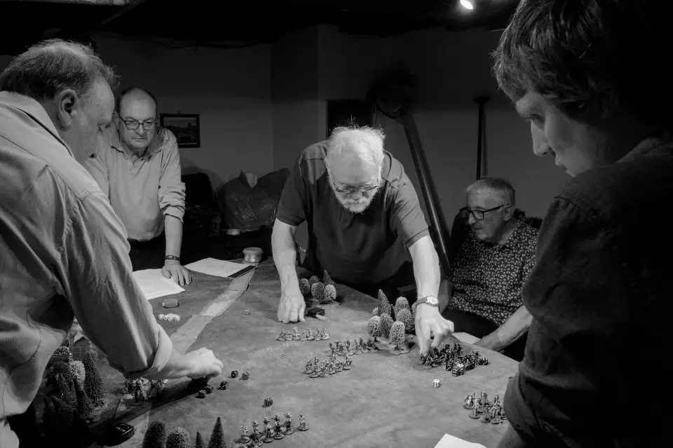 Men re-enact an historical battle using toy soldiers in the basement of a pub in Waterloo